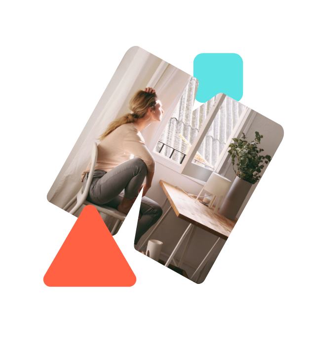 Eine Frau sitzt an einem Holztisch und rauft sich durch die Haare.