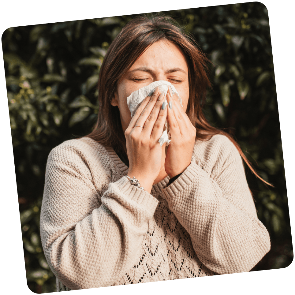 Frau leidet an Allergien und niest in ein Taschentuch